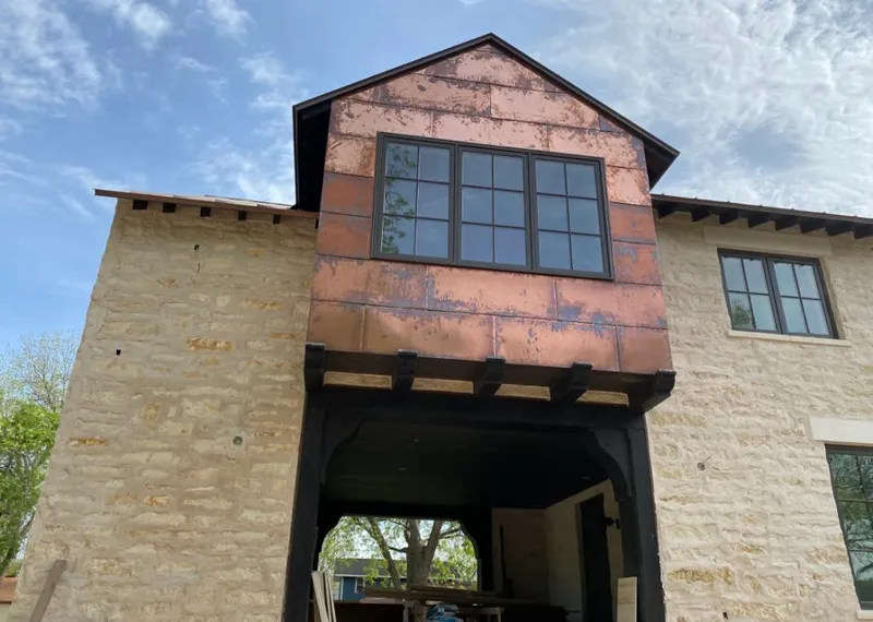 Copper metal panel facade on a stone building for Roof Repair in Barrington